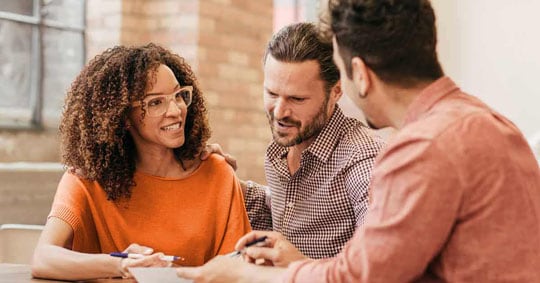 Three people looking at documents